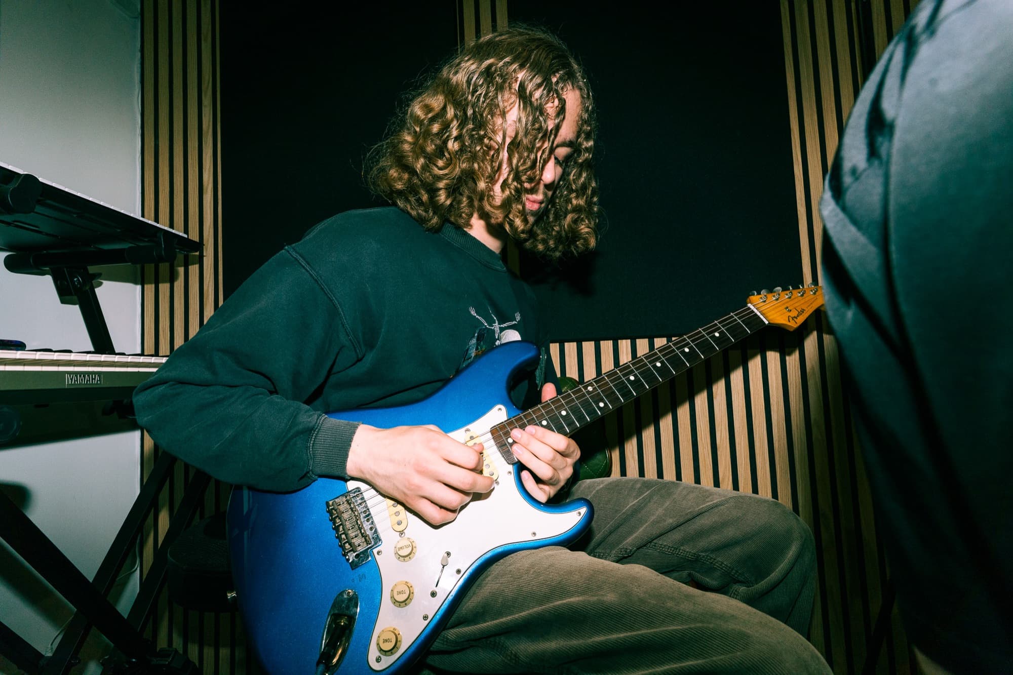 A young person at the studio desk during a music production session